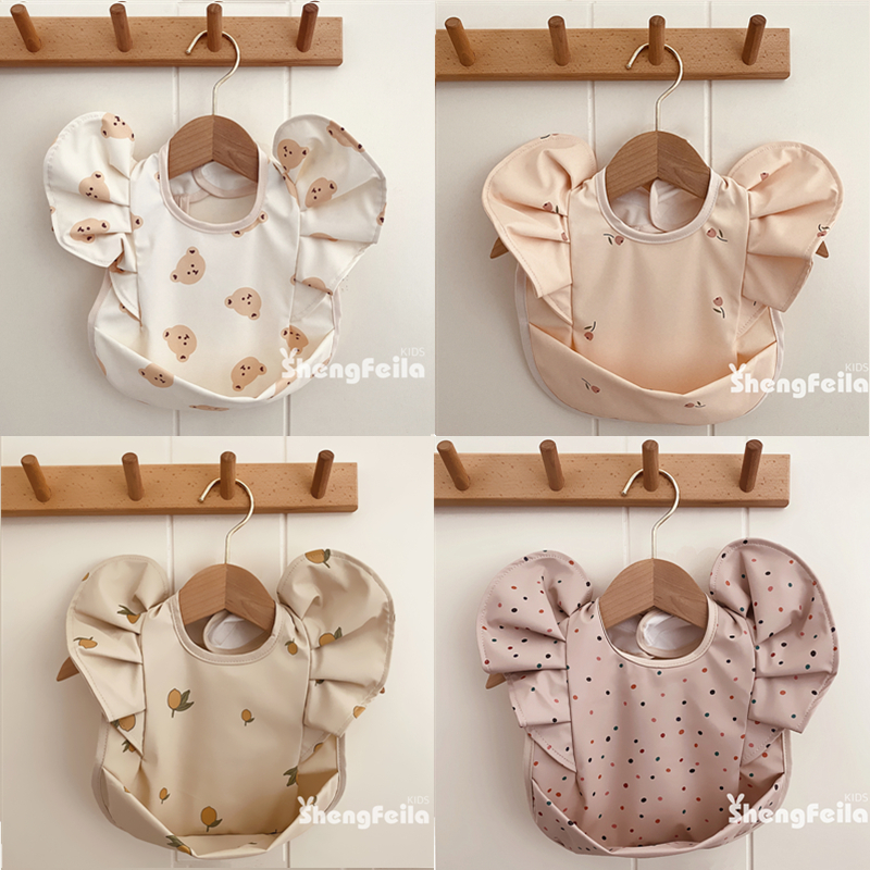 韓国の赤ちゃん用ポケット付き天使の羽の立体レースよだれかけ、防水プリンセス風の妖精のようなベビーフードよだれかけ、ソフト
