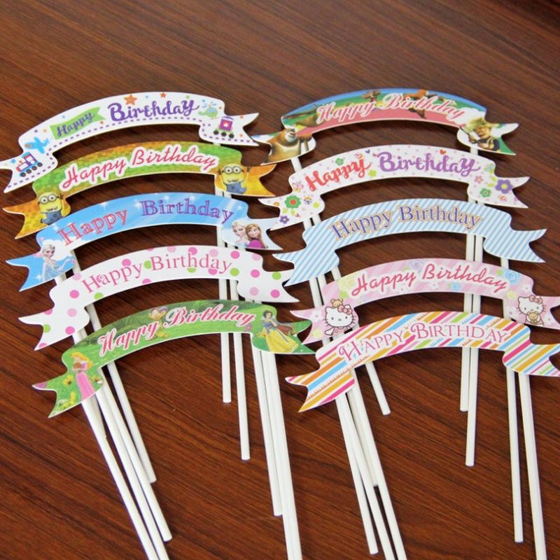 Birthday cake decorated with two pointed flowers, train inserts, happy birthday, flags, happybirthday