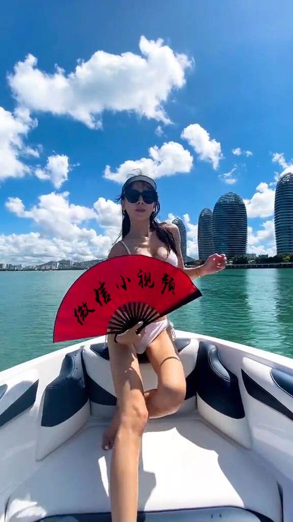 游艇上美女拿红扇子