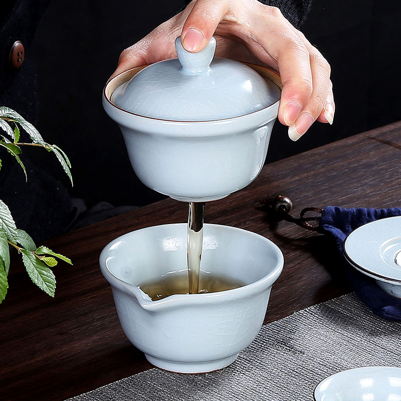 Crack cup against a pot of three cups of hot ceramics glass portable travel kung fu tea set contracted