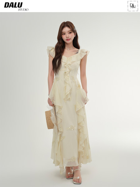 Model wearing a cream ruffled sleeveless dress