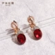 Длинная версия красных серег с золотой основой, приятная к круглому лицу.