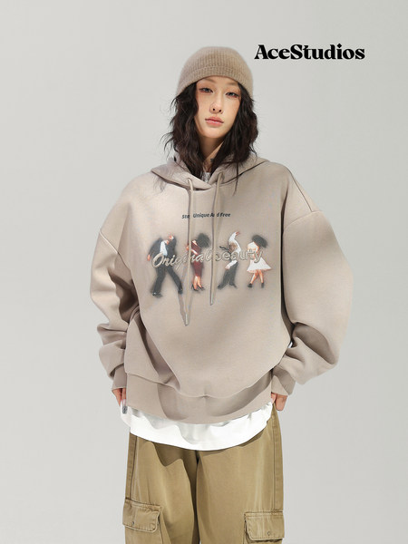 Model wearing a beige graphic hoodie with cargo pants and a knit beanie.