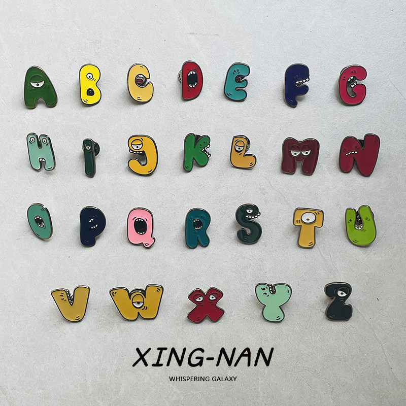 Cute cartoon monster metal brooches with the 26 letters of the English alphabet - personalized badges, student backpack accessories, and gifts.