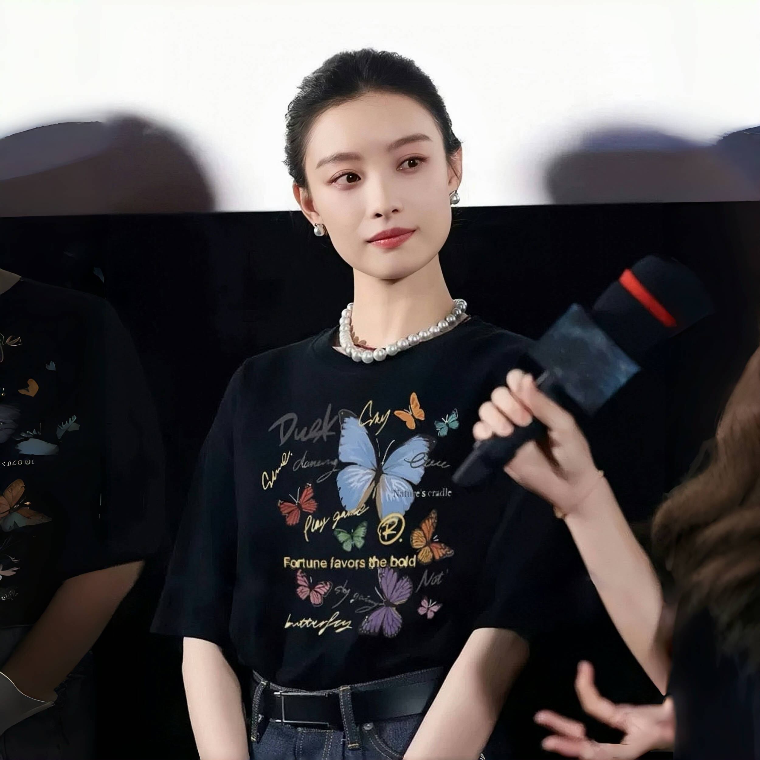 Ni Niのセレブ風プリント入り黒色半袖Tシャツ（レディース）。ユニークなデザインとカジュアルな雰囲気で、2026年夏の人気スタイルです。