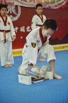 La performance a volé en éclats avec un taekwondo de boxe en marbre des arts martiaux avec une planche de performance en marbre jouant des matraques en bois