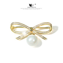 High-grade micro-inlaid zircon bow Pearl temperament brooch female simple buckle anti-light pin fixed clothing accessories