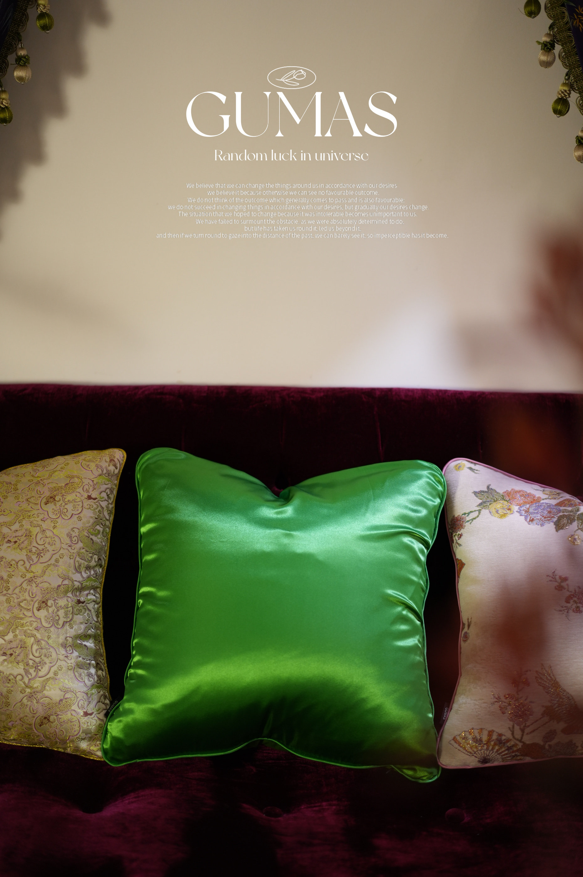 Close-up of multicolored floral embroidery with gold thread and beadwork on vibrant green silk cushion cover