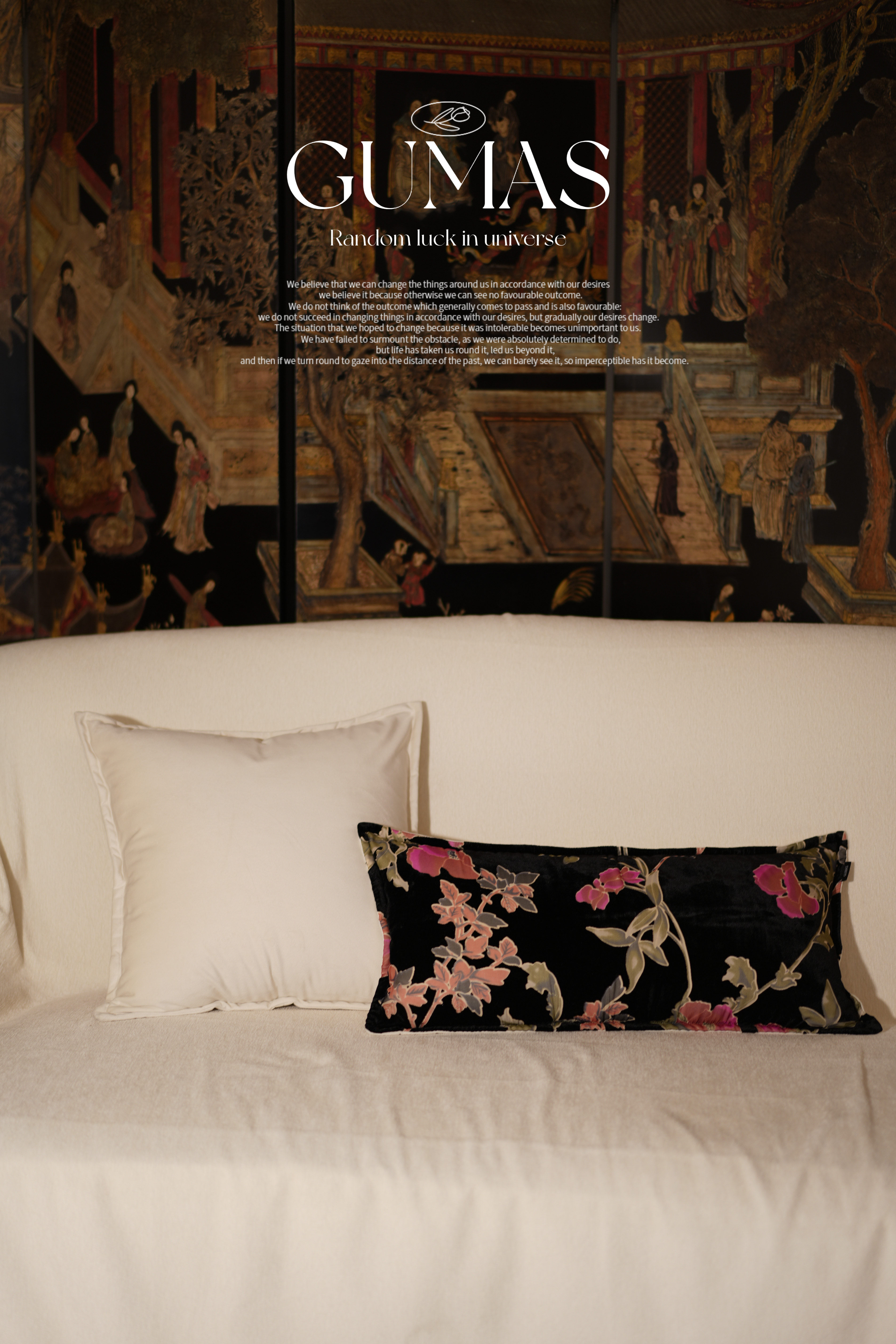 Black floral throw pillow styled on modern sofa with pink and coral blooming flowers