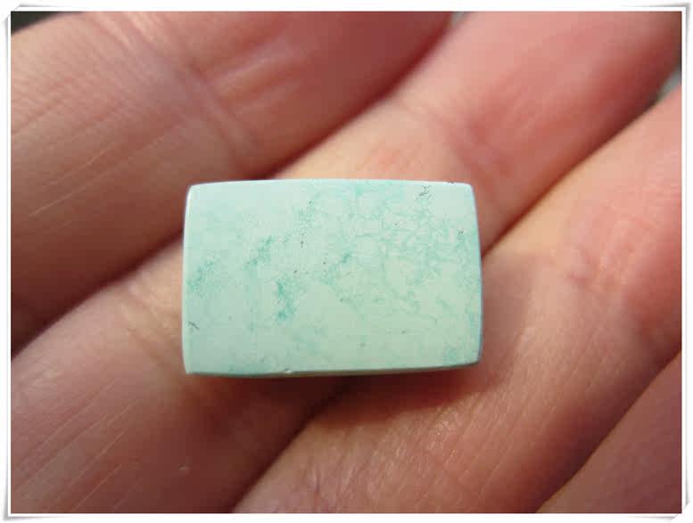 Turquoise card backed by the square raw mine