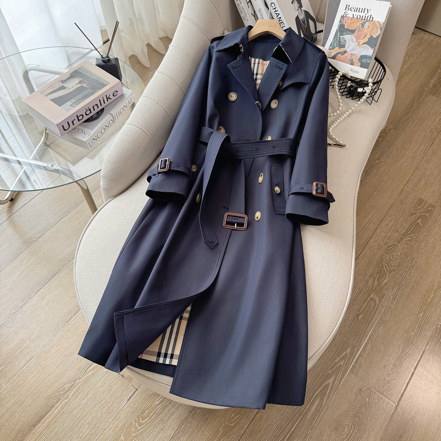 High-end navy blue long trench coat for women, British style, autumn, fitted, structured, with sharp shoulders and a cinched waist.