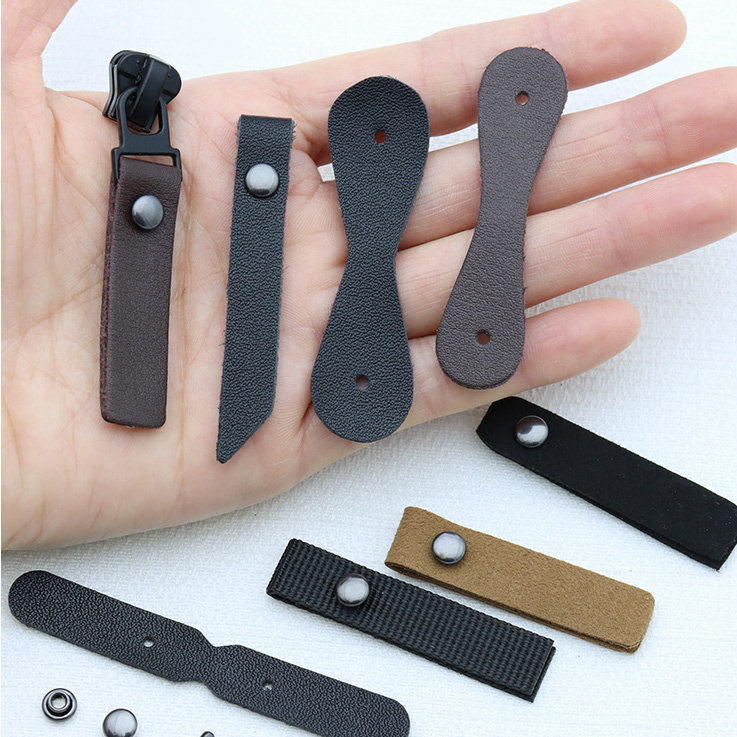 アウトドアウェア、バッグ、靴、ブーツ用の、リベット留めの革製プルタブ。取り外し可能なプルヘッドとドローストリング付き。