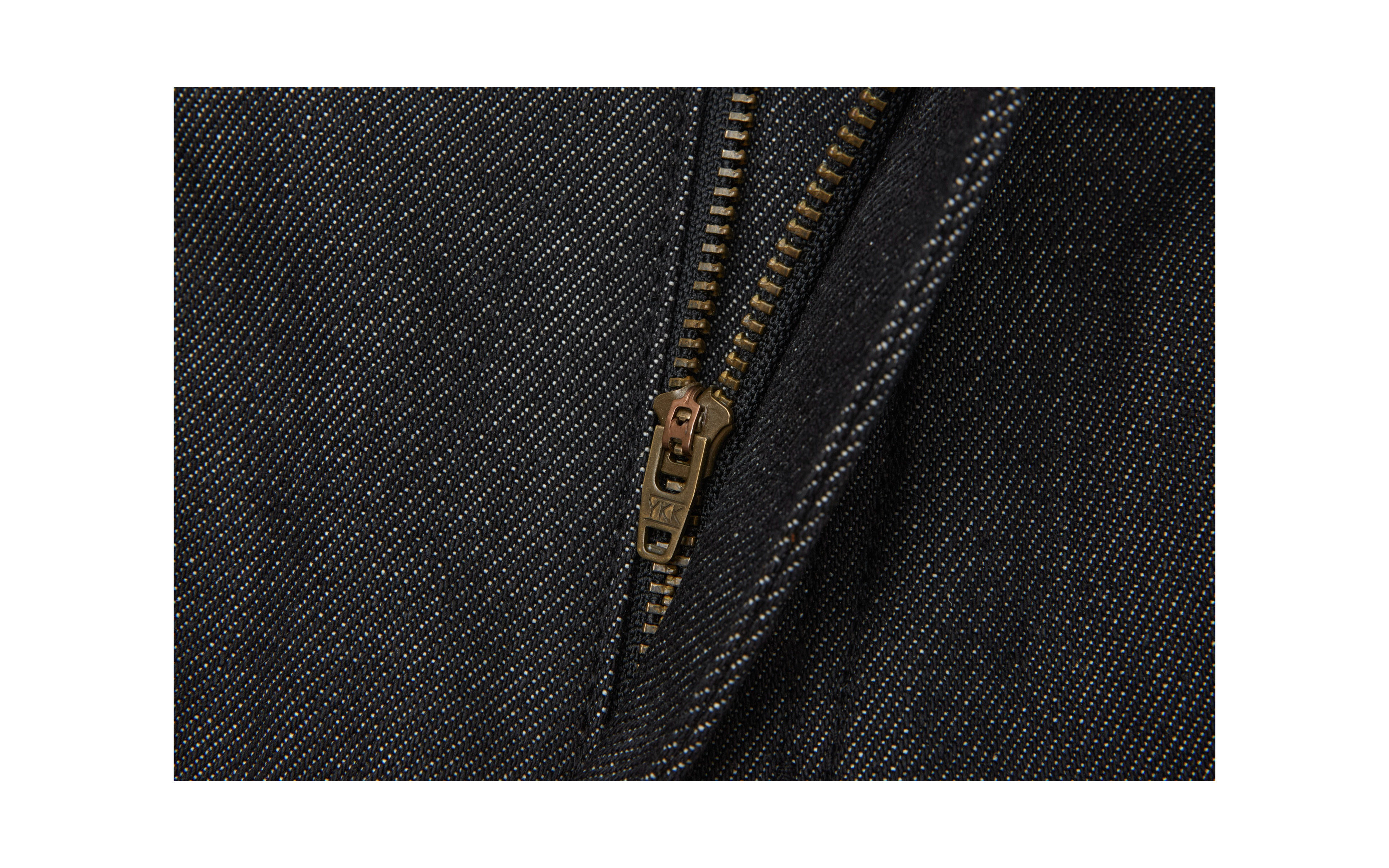 Close-up of a partially opened metal zipper on EastLyst Colorfast Black Flared Jeans, showing detailed zipper teeth and precise stitching on the cotton-poly denim.