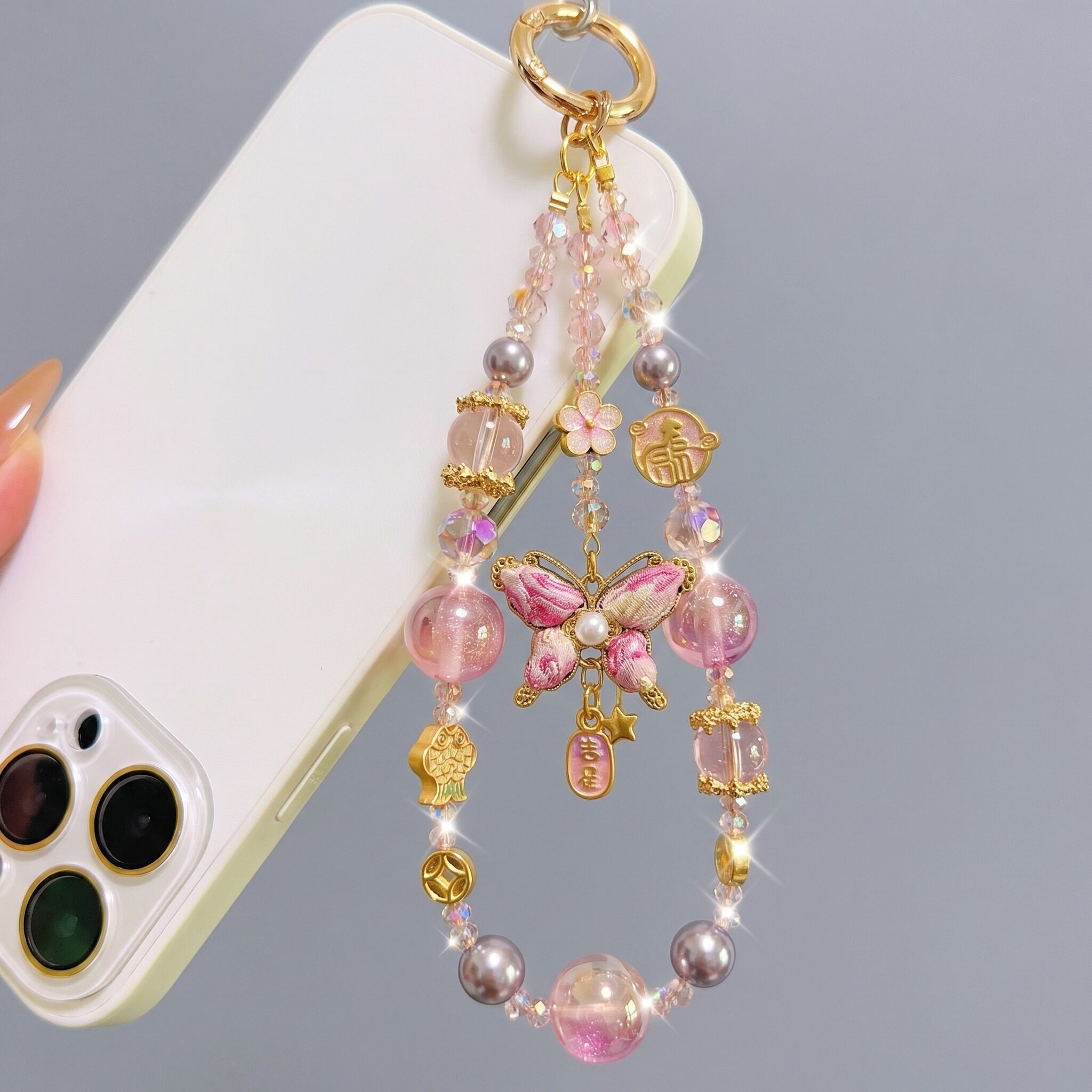 This new pink butterfly beaded phone charm is stunning, exuding a sophisticated and understated luxury. The delicate and high-end design features pink butterflies interwoven with gold accents, adorned with crystal pearls to convey a romantic style.