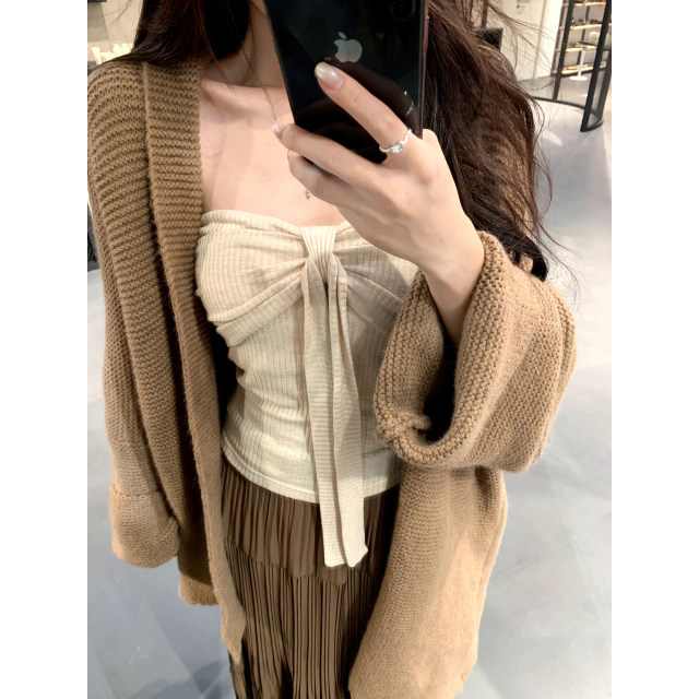 A sweet peach yikett <Soft and Beautiful> two-color knitted vest worn inside a women's tube top