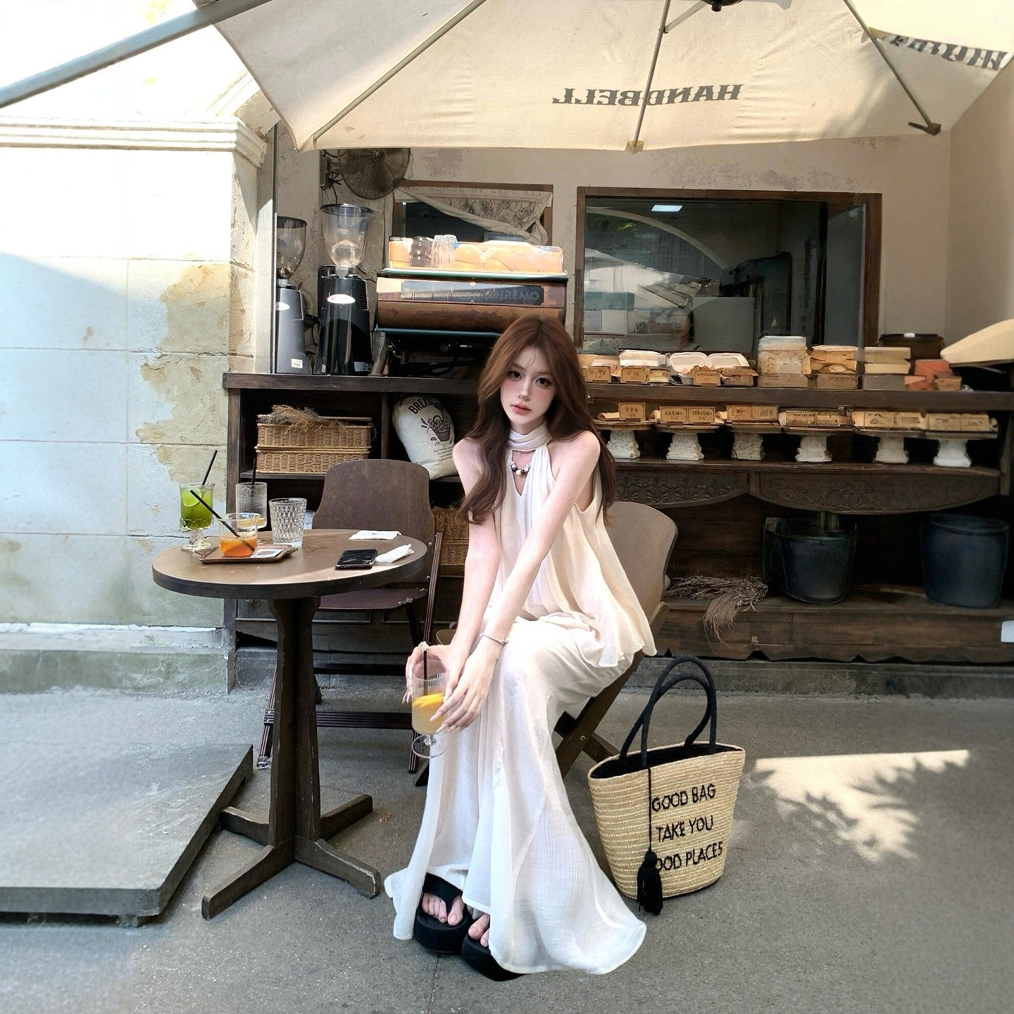 白の洗練されたホルターネックタンクトップ、リボン付きのノースリーブトップス、そしてワイドレッグパンツが、リラックスした気取らない夏の装いを演出します。