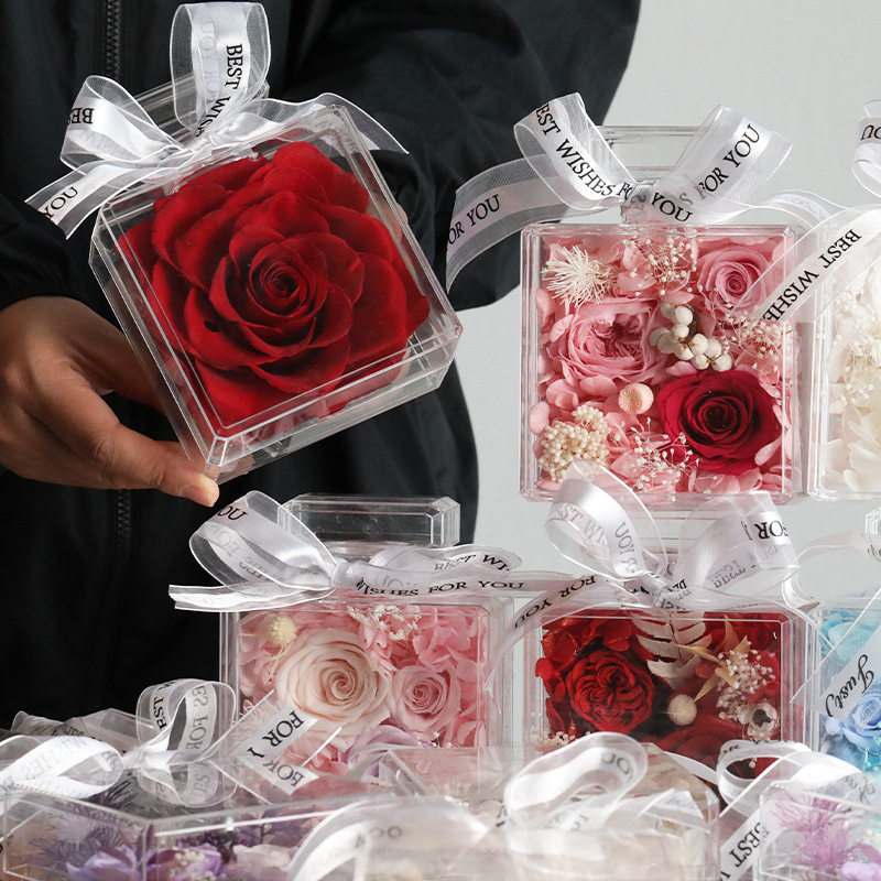 Close-up of preserved roses arranged inside a clear acrylic case