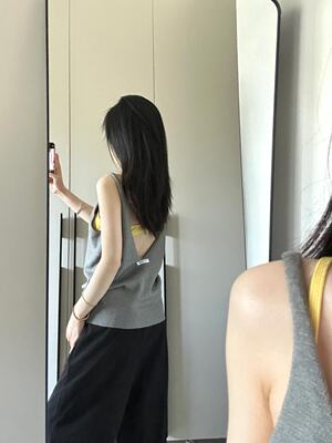 A large backless grey knitted vest with a halter top, a summer hot girl style, loose sleeveless black top worn over it