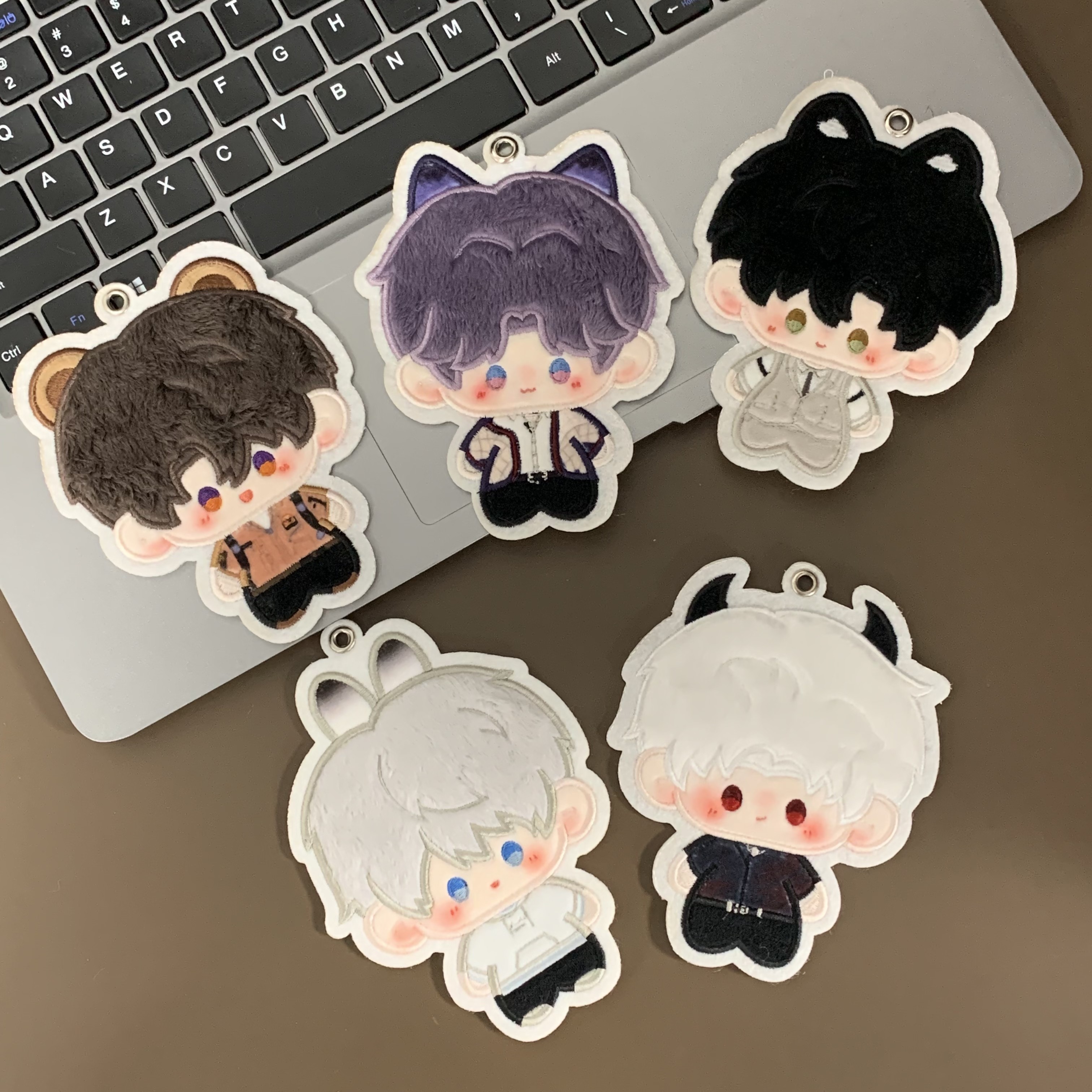 Fan-made Love and Deepspace plush charms beside a keyboard