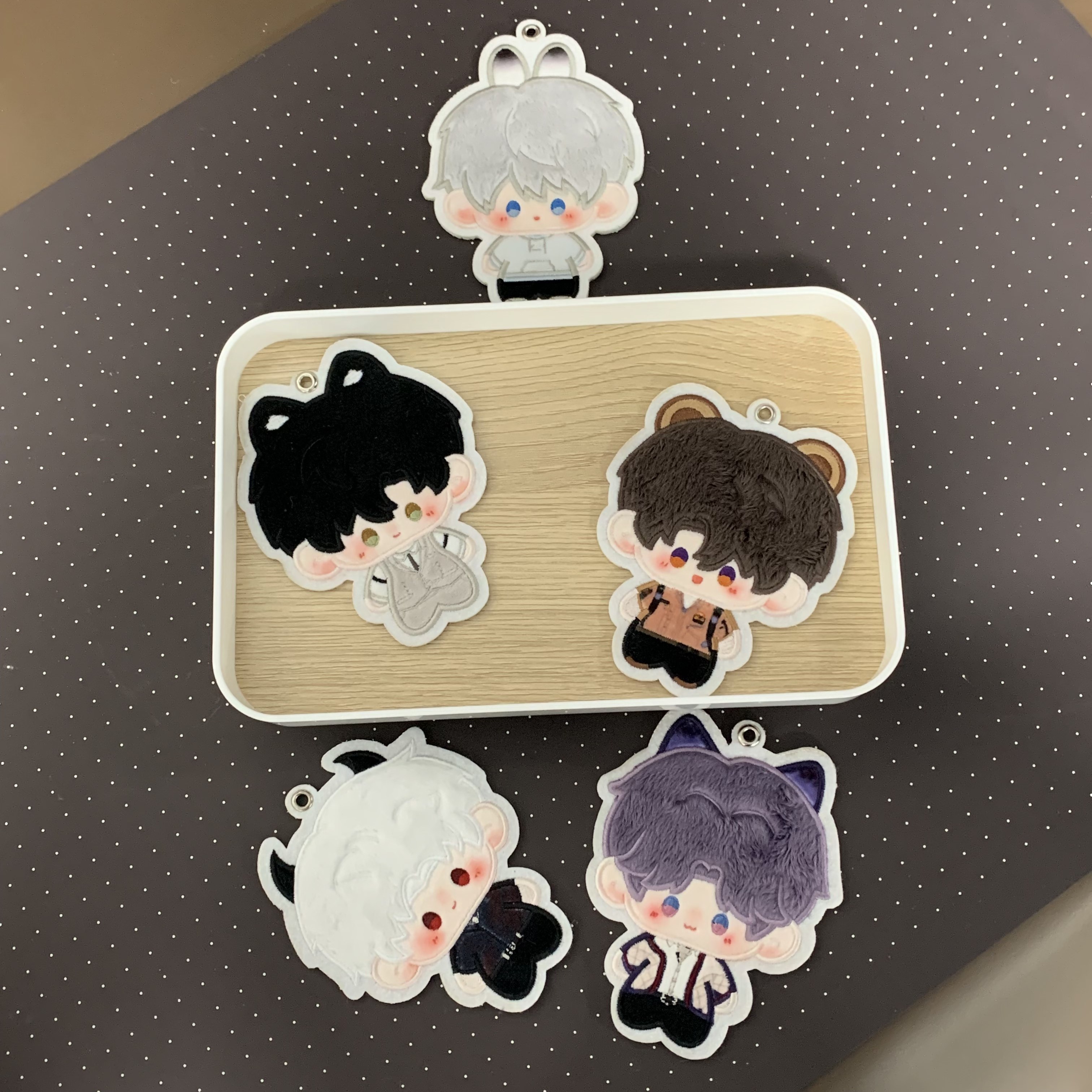 Five Love and Deepspace character plush charms arranged on a tray