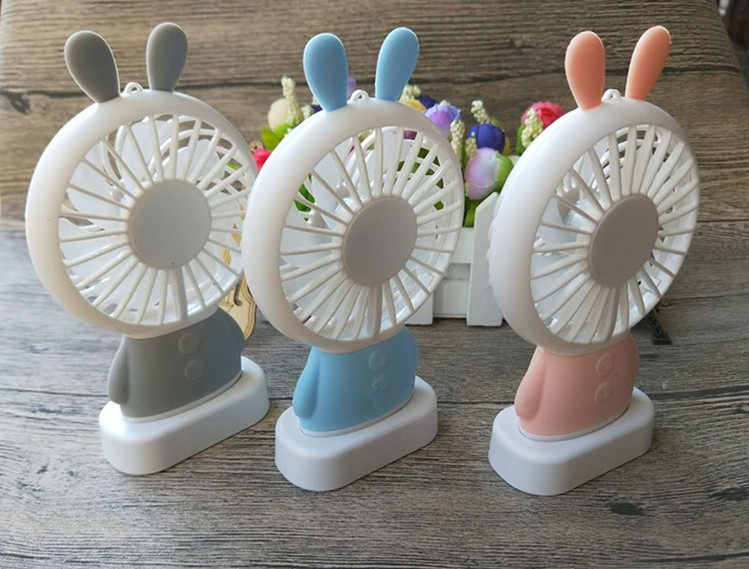 Small white rabbit USB handheld mini seven colored lights electric fan can charge small portable carry-on cartoon desktop