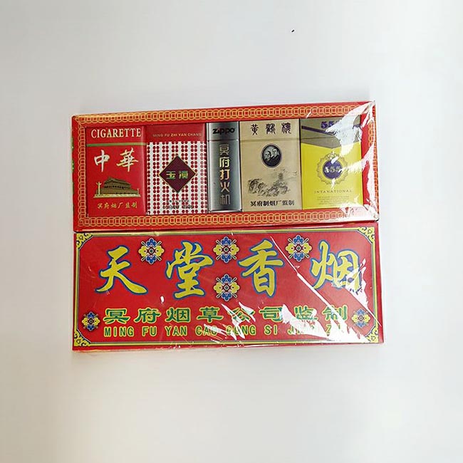Worship at the grave of the grave and meditate paper money burning paper cigarette gift boxes.