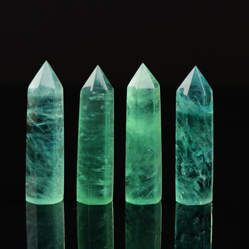 天然の緑色の蛍石の結晶柱状装飾品。透明で緑色をしており、研磨された六角形の結晶プリズムから作られています。