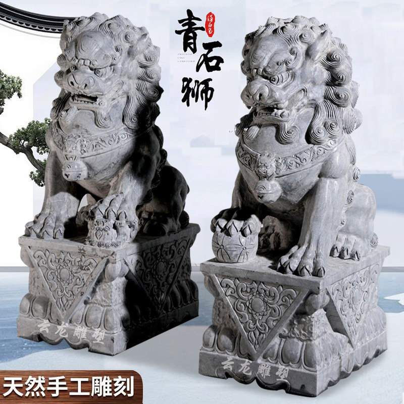 A pair of bluestone stone lions at the gate of a large villa at the gate of the house
