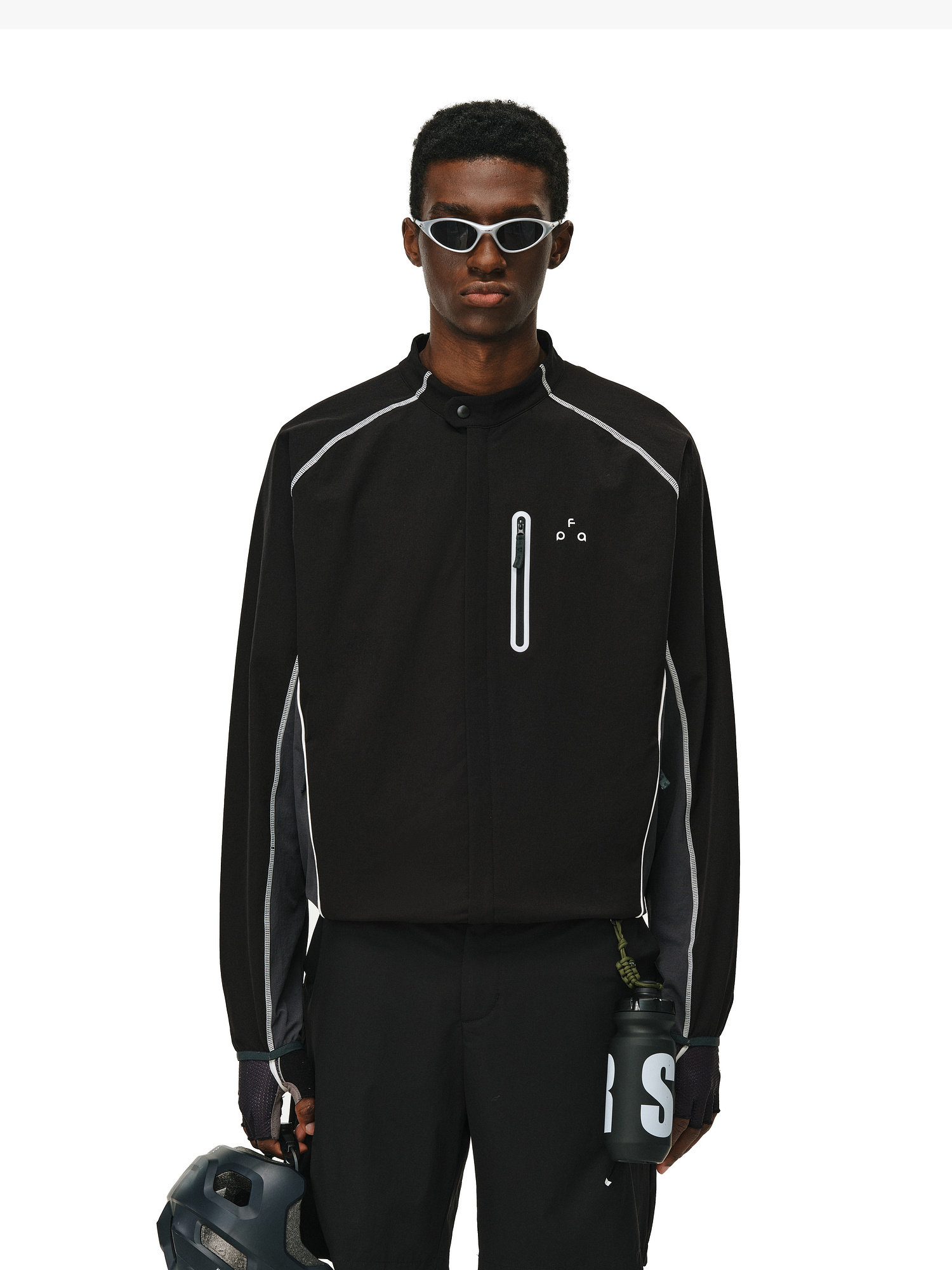 Wearing the EastLyst Contrast Color Jacket, four-way stretch hiking pants, and white sunglasses, a person stands against a white background holding a black helmet and water bottle—ready for outdoor adventures.