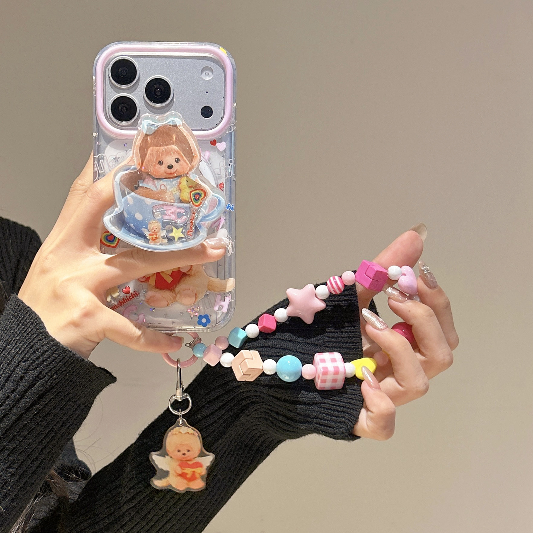 Cute and adorable Monchhichi rocking magnetic stand for Apple iPhone 17 Pro Max, iPhone 16, 15 Pro, bracelet, girly style, and drop-proof protective case.