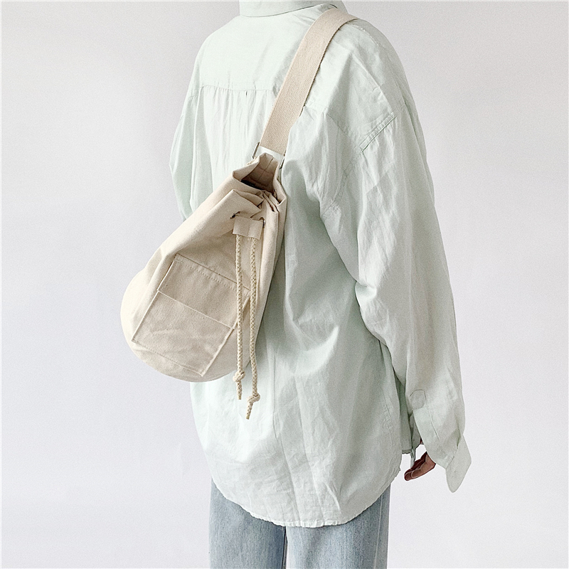 Bai Qi Korea ins retro drawstring design simple and versatile solid color diagonal bag tide canvas one-shoulder cloth bag for men and women
