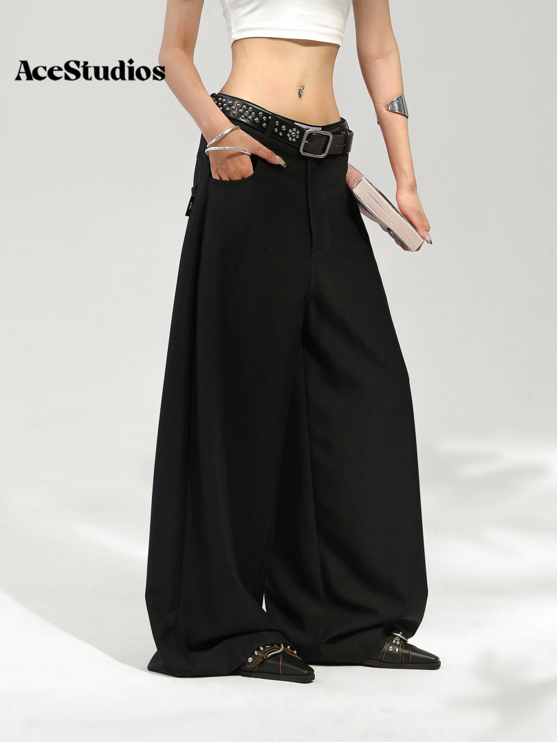 Model wearing black wide-leg pants with a belt and cropped white top