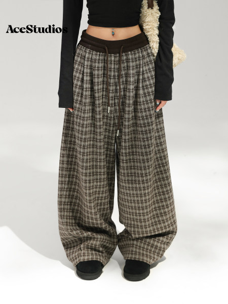 Model wearing wide-leg brown tweed trousers with a black cropped top.