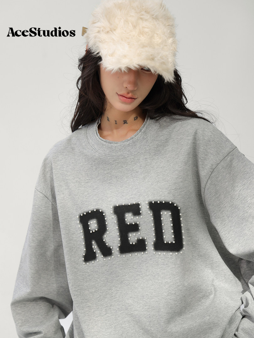 Gray oversized sweatshirt with a black and white “RED” graphic worn by a model.