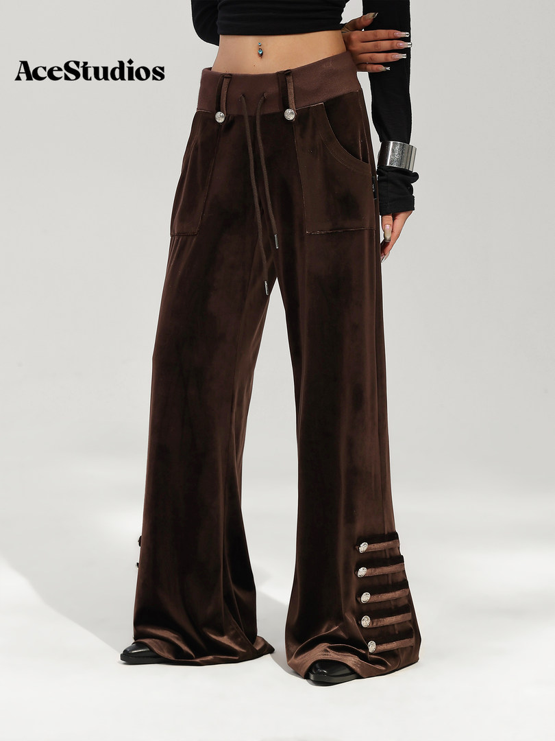 Model wearing dark brown wide-leg cargo pants with decorative straps and hardware.