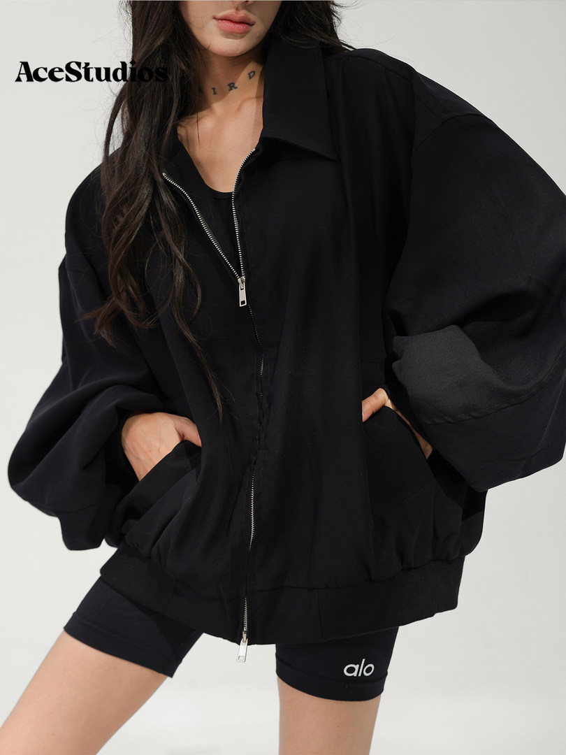 Model wearing a black oversized zip-up jacket with black athletic shorts