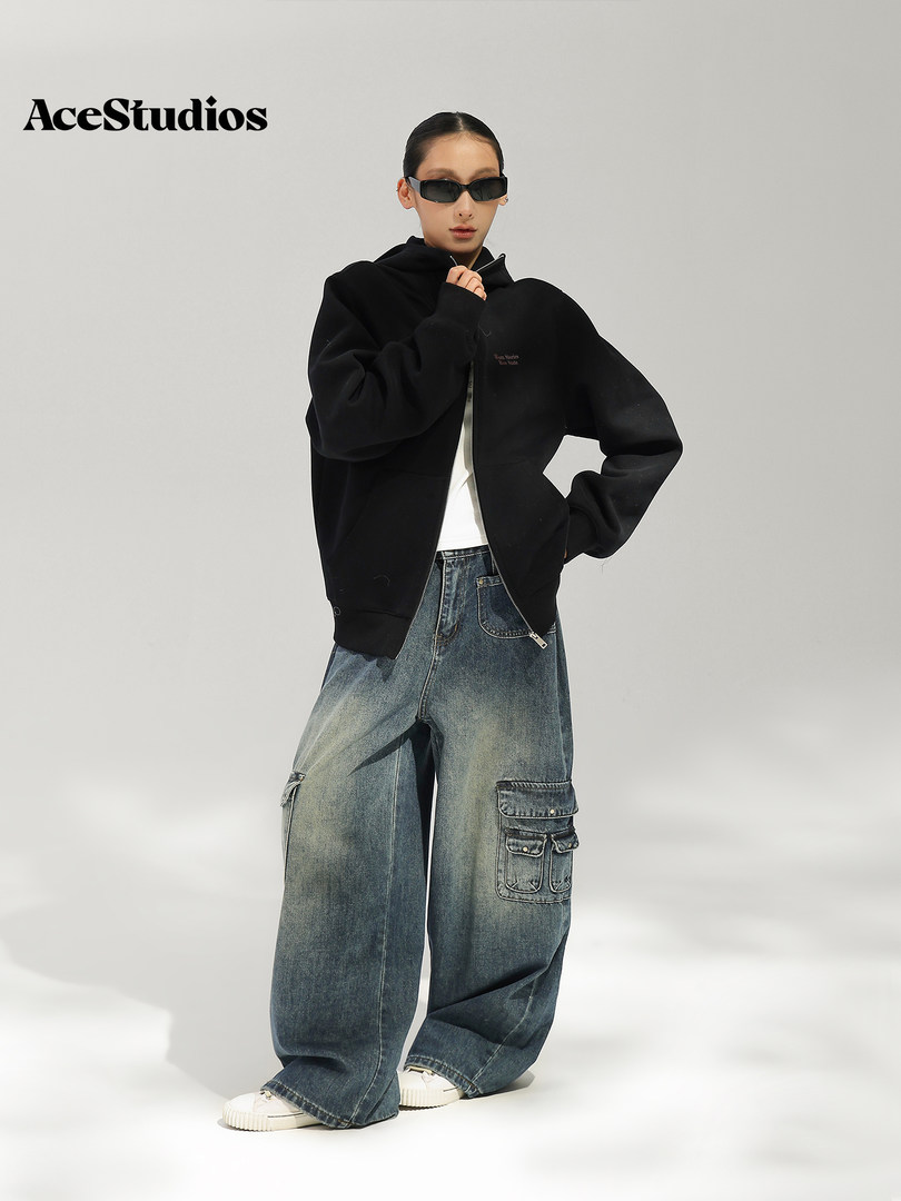 Model wearing a black jacket with oversized distressed cargo jeans and sunglasses.