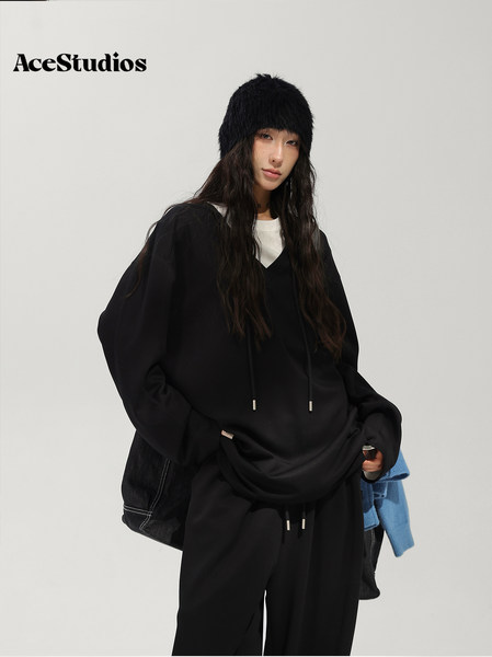 Model wearing an oversized black hoodie and pants with a black beanie.