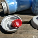 Новая американская полярная бутылка белого медведя, спортивная рука с холодной верховой ездой держит утечку -наряду с дороги.