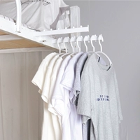 Общежитый артефакт одежды вымощен одеждой и зацепит студенческую спальню спальню кровати кровати кровать кровать кровать для головы навеса вешалка