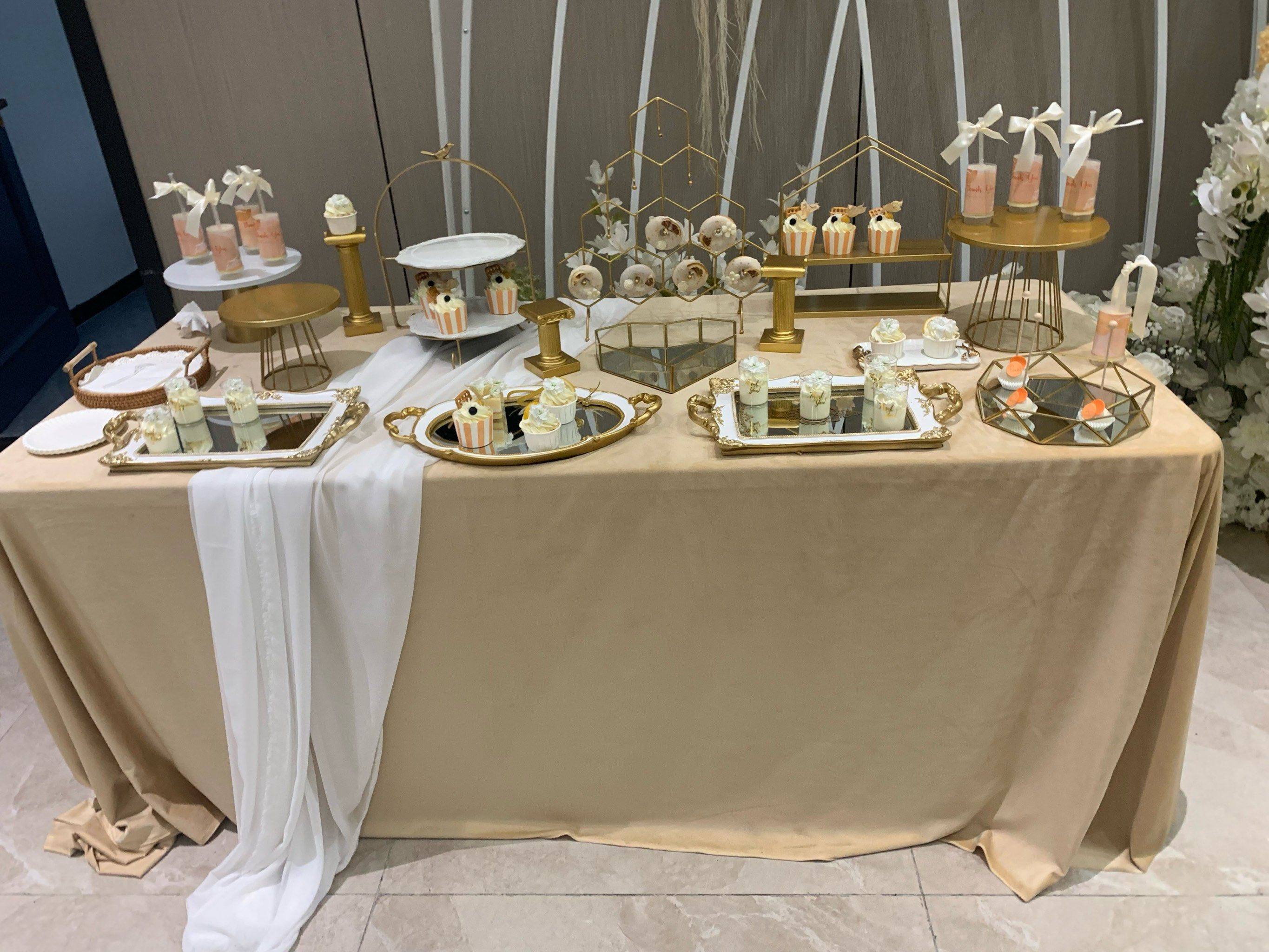 Selection of minimalist wedding decor items such as glass vases, candle holders, and neutral linens arranged on a table