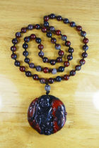 Natural Guilin chicken blood jade red handle on black background jadeized red jade bead tag fortune boy will bring fish every year