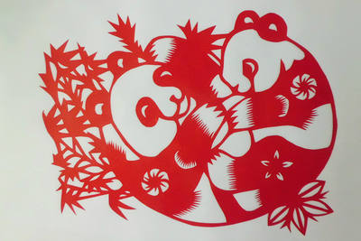 Paper-cut panda, a national treasure animal, is a jianzhi art piece. It is a double-sided red Xuan paper work with a student's slip